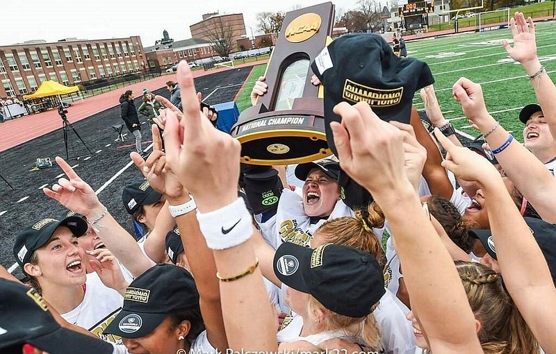 The team celebrates holding the trophy high.