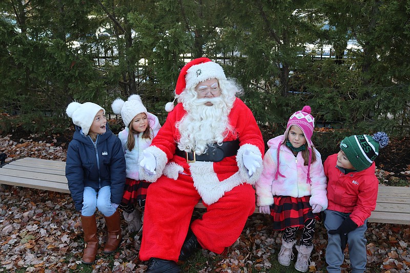 From left, cousins Abi Young, 8, and Kayla Smull, 5, tell Santa what is on their wish list, with the help of their siblings, Chloe Smull,7, and 5-year-old Christian.