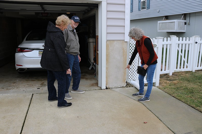 Romaine and Warren Reiner watch as their daughter, Kim Lasinski, points to flooding damage to their home on West 17th Street.