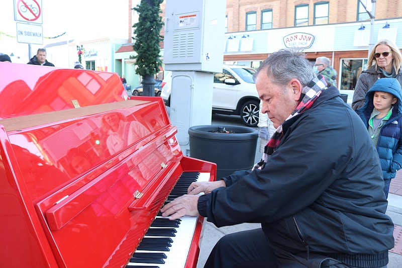 Shawn Quigley performs on his eye-catching red piano.