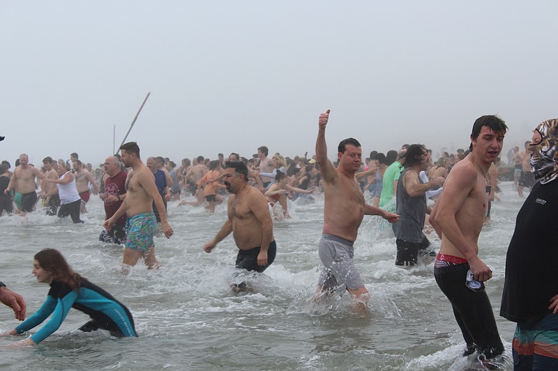 Ocean City resident Michael DeVlieger raises his hand in triumph while heading out into the ocean. (Photo courtesy of Ocean City)