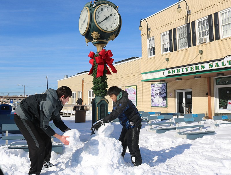 Robert Vasjuta, left, and Rob Malfitano build a snowman on the Boardwalk at Nionth Street.