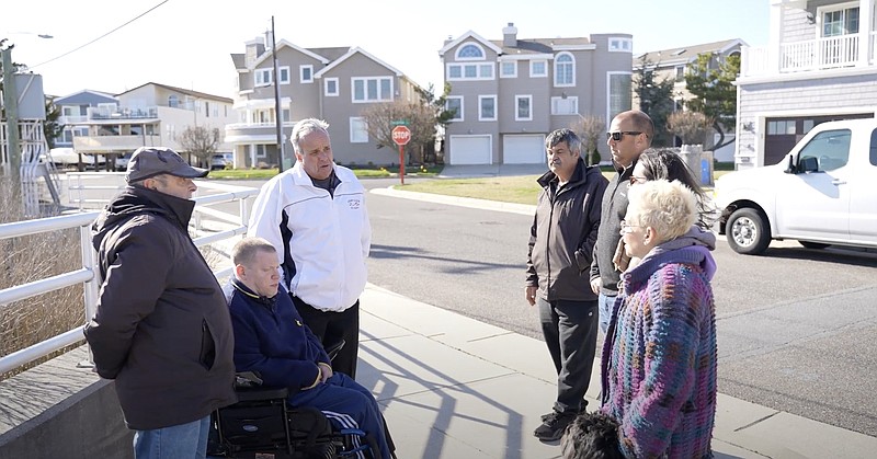 Mayoral candidate Keith Hartzell, in white jacket, goes door to door in Merion Park.