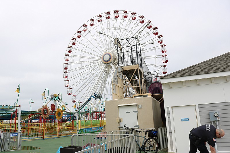 A police officer is stationed outside of the Wonderland Pier amusement park after the fatal fall Monday morning.