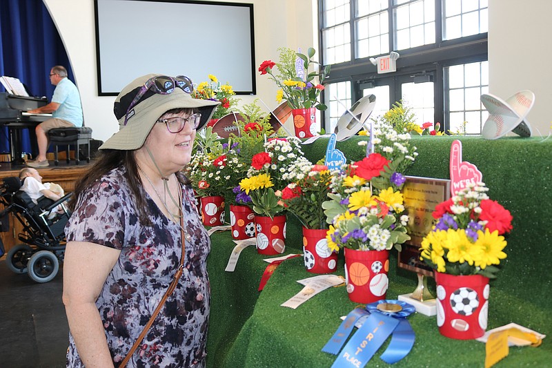 Susan Bundy, of South Plainfield, N.J., admires some of the entries in the 2022 flower show.