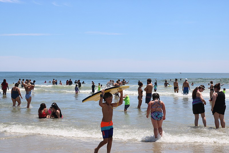 Swimmers and boogie boarders enjoy the water.