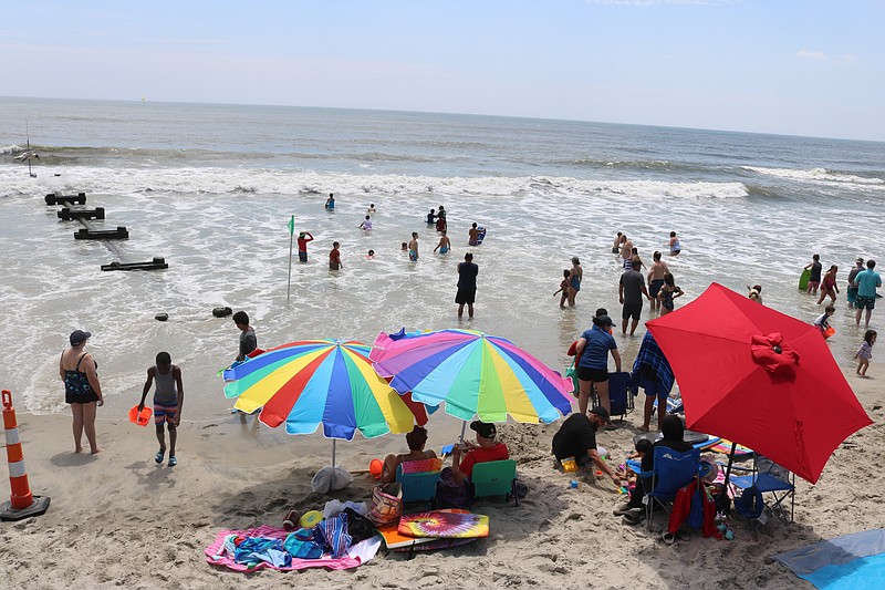 Beachgoers hop in the water to escape the heat in July.