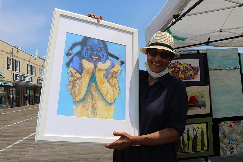 Artist Michele Foster Lucas proudly displays her favorite work, "Giggles."