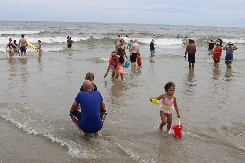 Some families wade in the cool water.