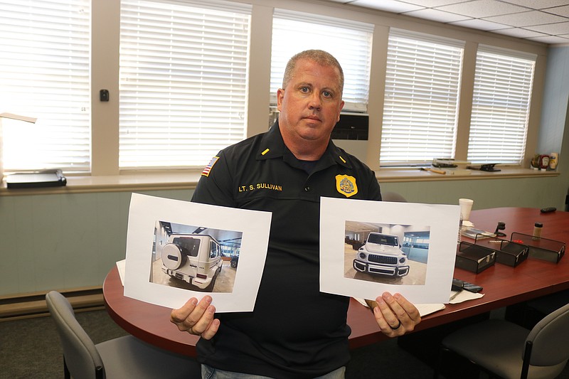 Police Det. Lt. Steve Sullivan holds photos of one of the high-end Mercedes G Wagons stolen in September in Ocean City.