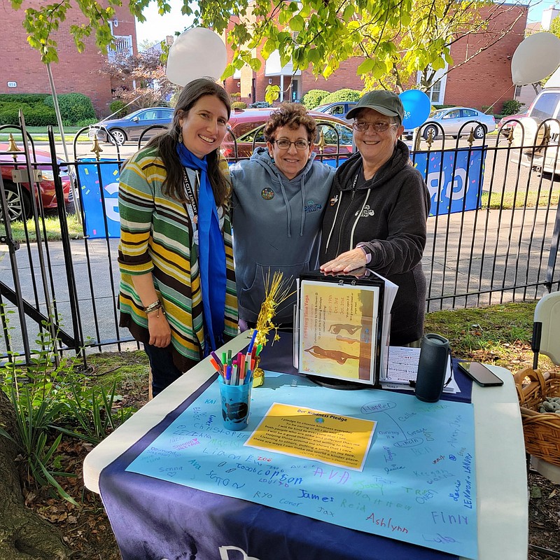 From left, Children's Librarian Taimi Kelley, library assistant, Pat Jackson and Children's Librarian Maureen Edwards share a light moment during a StoryWalk.