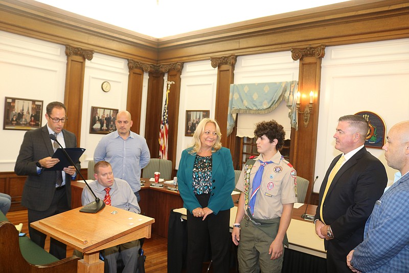 City Council President Pete Madden, far left, reads a proclamation honoring Chase for this high achievement.