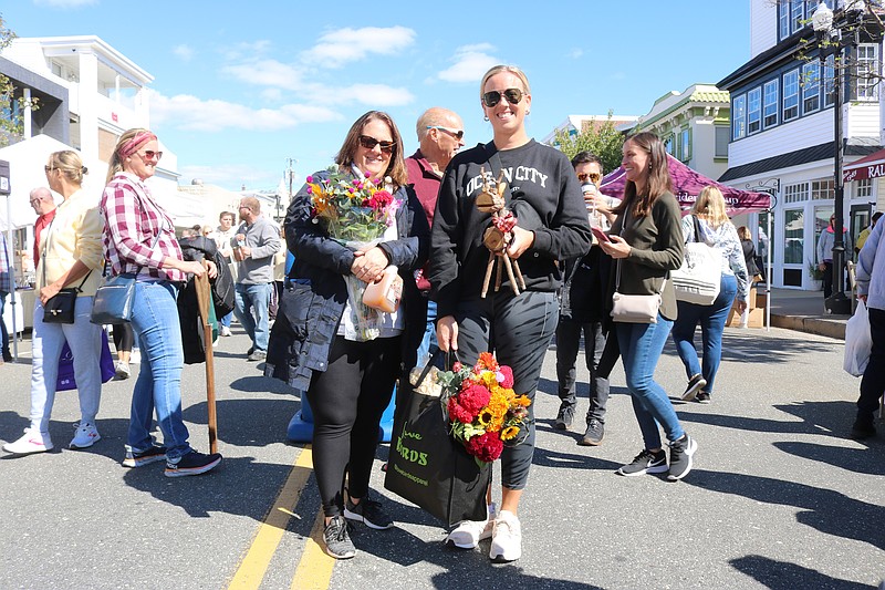 Friends display some of their bright colored floral arrangements from vendors.