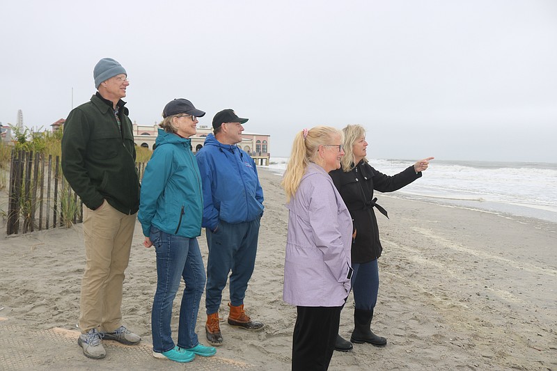 Dana O'Neill points at some big waves, while her friends, Lisa Pauwels, to her right, and back from left, Fred and Sharon Martenson and Greg Pauwels look on. 