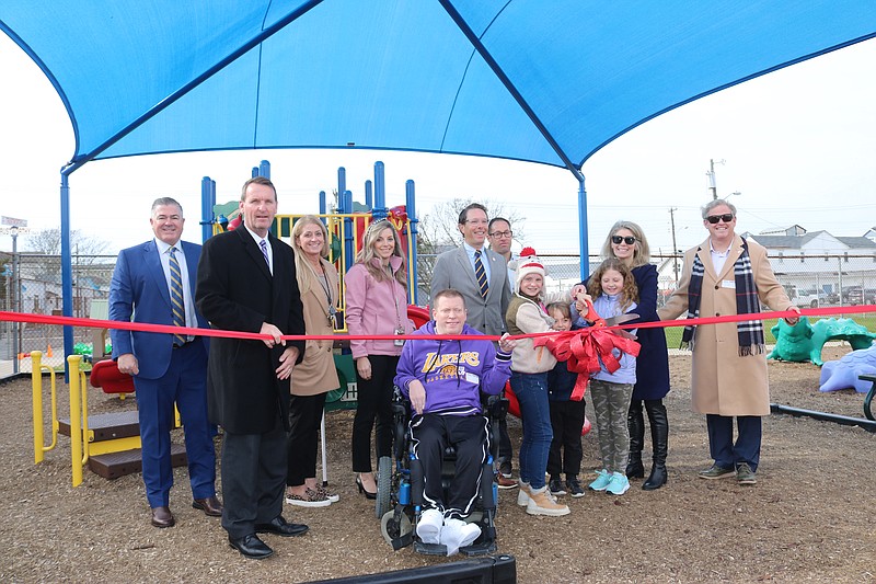 Mayor Jay Gillian, in black coat, joins with Ocean City Council members and school officials to cut the ceremonial ribbon for the shade structure.