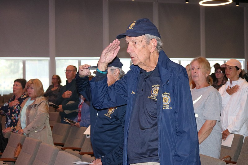 Two veterans salute during the Pledge of Allegiance.