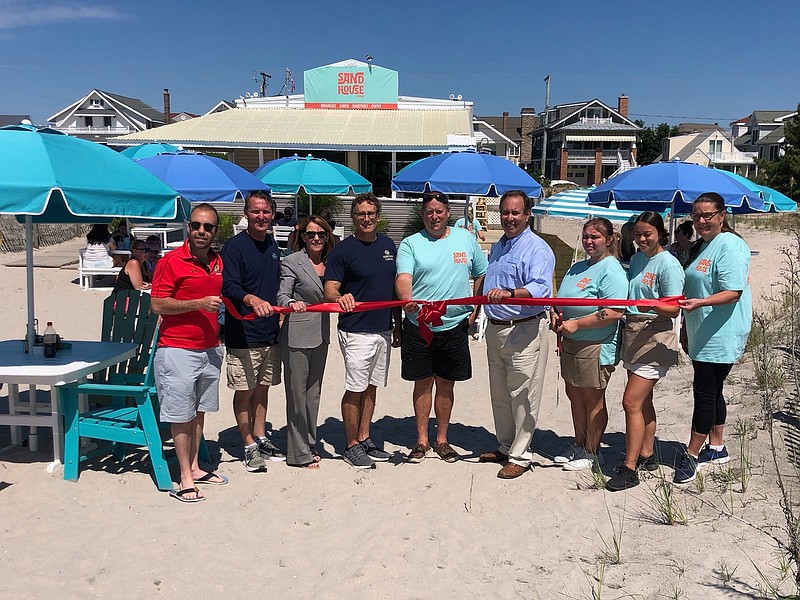 State and city officials gather with the Idell family and staff for the Sand House Kitchen ribbon cutting in June 2021. (Photo courtesy of Sand House Kitchen)