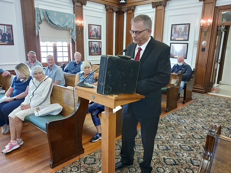 Ocean City resident and realtor John Walton addresses City Council with his leather briefcase he takes into the ocean each year. 