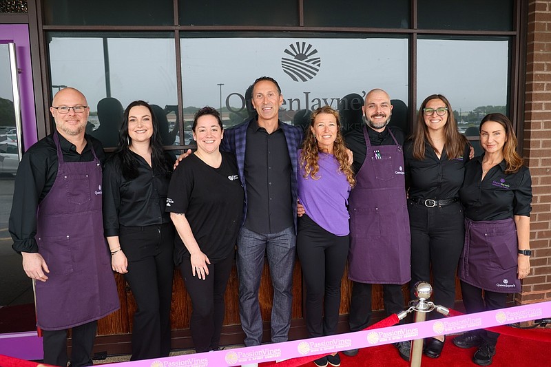 Michael Bray, center, with his wife, Kimberly, purple shirt, and staff during the May 20 ribbon cutting ceremony. 