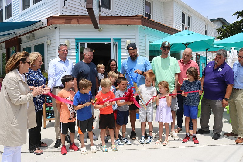 Soulberri’s owners James and Jenny Develin get a little help cutting the ribbon as family, friends and dignitaries show their support.