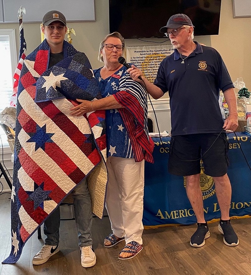 Staff Sgt. Austin Root holds his Quilt of Valor.