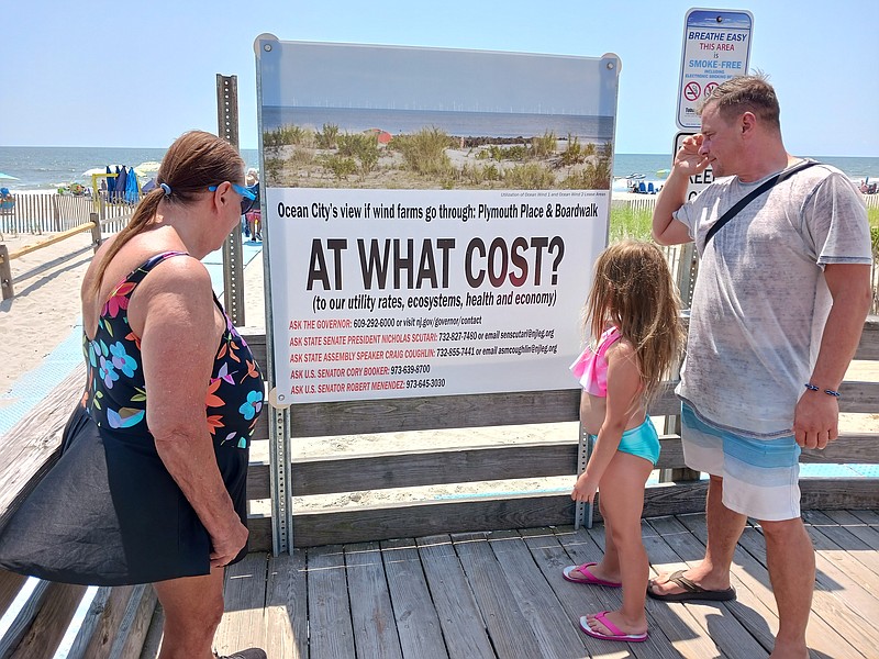 Sharon Jaeger, a tourist from Cleveland, and her son, Rob, and his daughter, McKayla, check out the new sign at Sixth Street and the Boardwalk on the ramp to the beach.