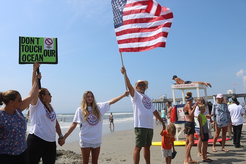 Robin Shaffer, of Ocean City, holds the American flag and hands of fellow protesters.