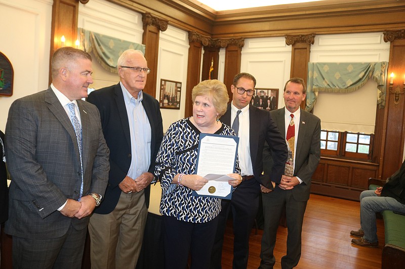 Breast cancer "thriver" Jeanmarie Mason receives a proclamation from city officials in recognition of Breast Cancer Awareness Month. 