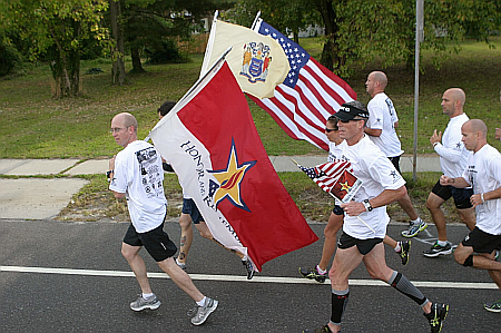 Runners carry flags for armed forces as well as the American Flag.