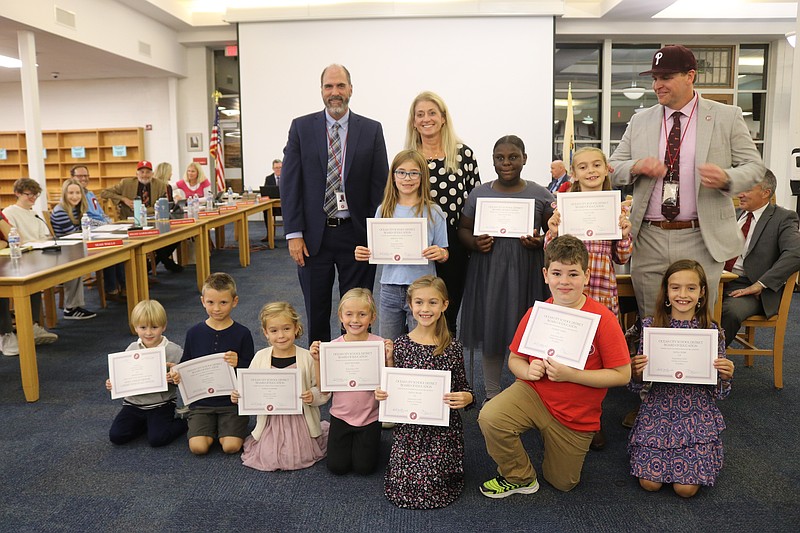 Primary School students selected as Students of the Month are joined by school officials for a group picture.