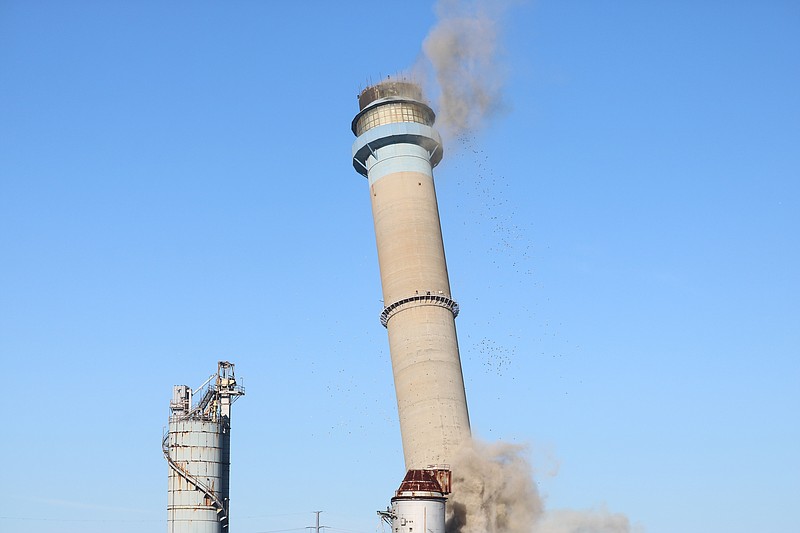 The smokestack falls to the ground.