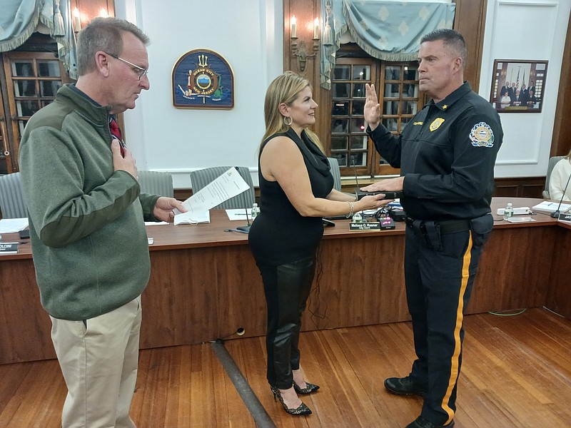 With his wife, Jill, holding the Bible, Bill Campbell is sworn in as Ocean City's new police chief by Mayor Jay Gillian.