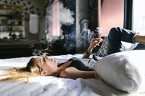 https://www.pexels.com/photo/a-woman-in-black-tank-top-lying-on-the-bed-while-smoking-weed-8139667/