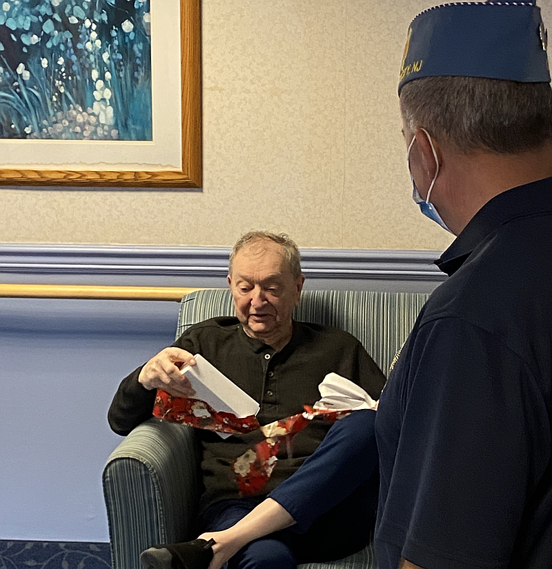 Sons Commander Mike Byerly visits a veteran in his apartment and gives him a Christmas gift.