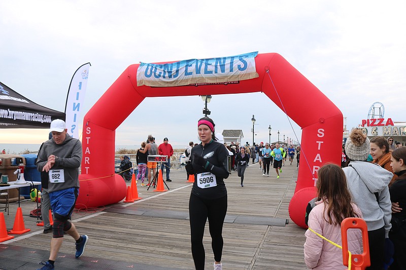 Runners cross the finish line on the Boardwalk.