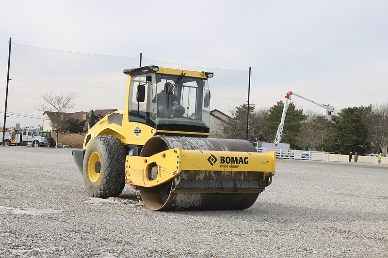 A worker makes sure to compress the materials into the ground.