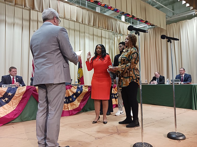 Commissioner Melanie Collette, in red dress, is sworn in by former Middle Township Mayor Timothy Donohue, while accompanied by her sister, Anika Collette, and nephew, Jalen Freeman.