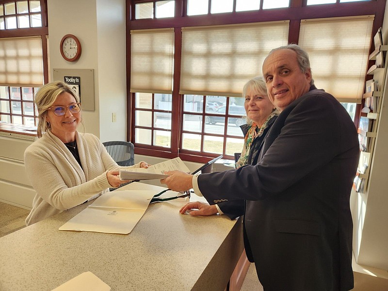 City Council candidate Keith Hartzell hands his nominating petitions to City Clerk's Office assistant Nicole Driscoll while accompanied by his campaign manager Susan Cracovaner. (Photo courtesy of Keith Hartzell)