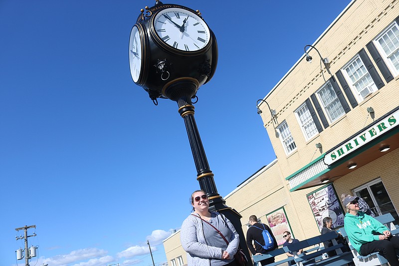 Rain Gentner poses next to the new clock.