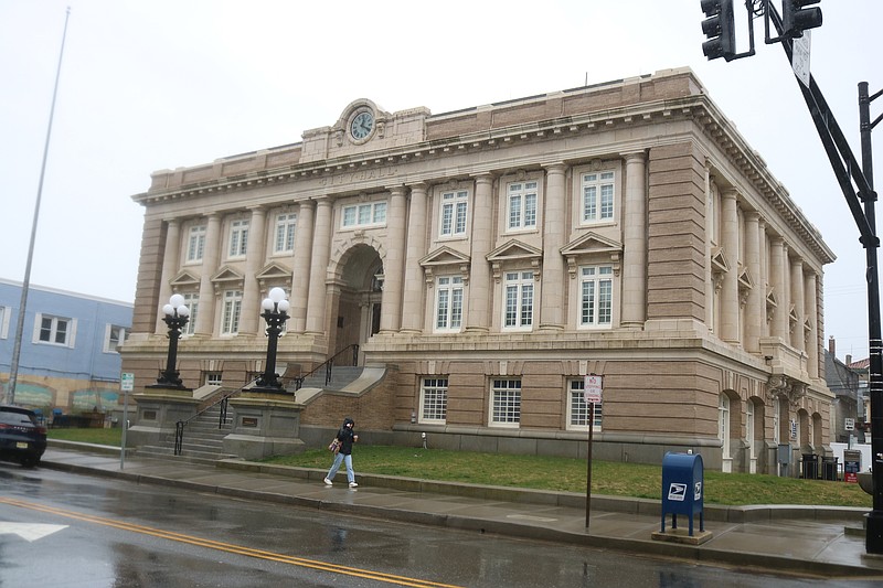 One person briskly walks by City Hall on a rainy Saturday.