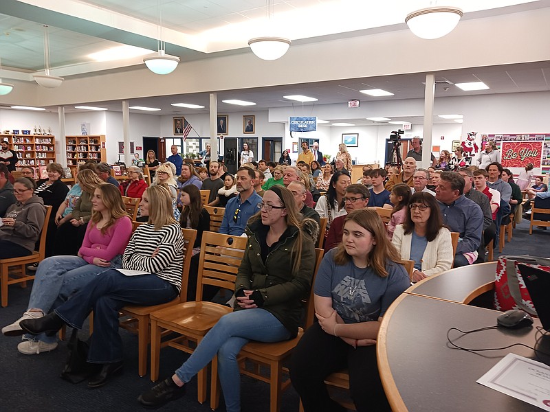 The audience fills the media room for the school board meeting.