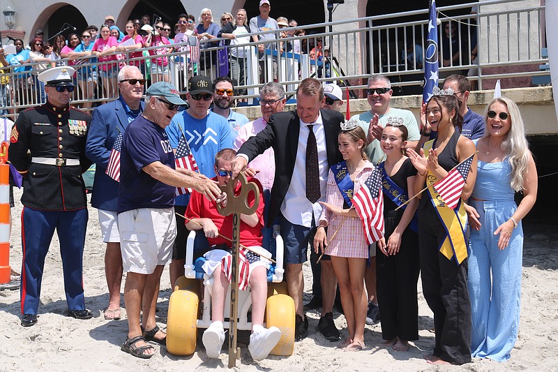 Mayor Jay Gillian, with the help of historian Fred Miller and Cape May County Commissioner Bob Barr, turns the ceremonial wooden key to "unlock" the ocean in 2024.