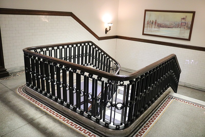 The ornate staircase leads to the second and third floors of the historic building.