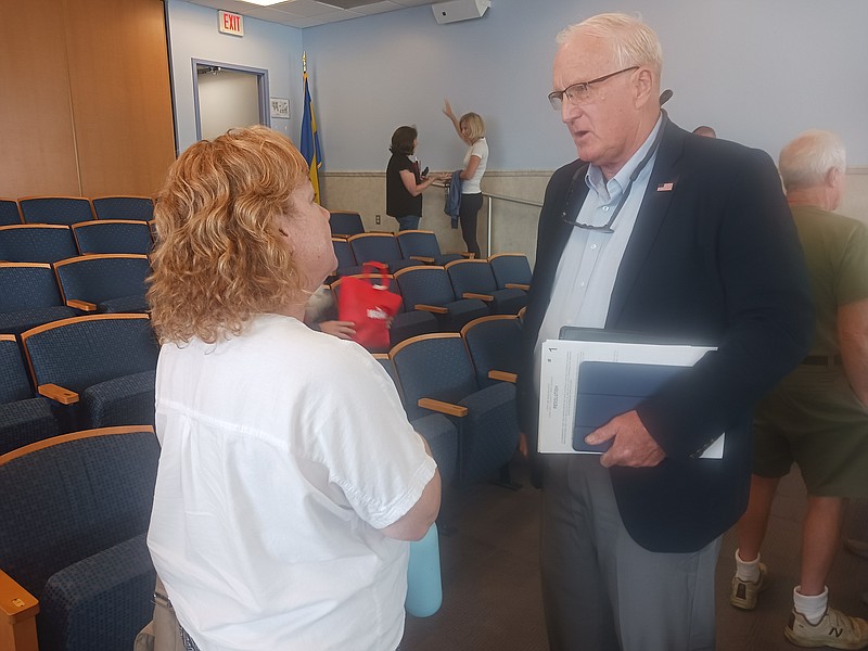 Maggie Jacqueline, one of the Seaspray condo owners, speaks with Councilman Dave Winslow after the meeting.