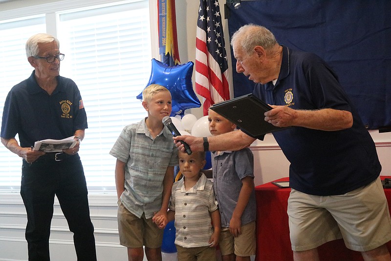 Post 524 member Steve Cole presents the Panaccione children with ceremonial medals.