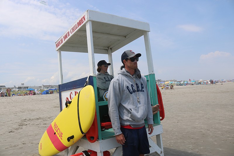 Lifeguards Bill Stinson, standing, and Theodore Rowe keep watch for bathers at 55th Street beach.