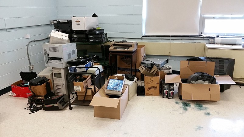 Old computers and other discarded office equipment are piled in the corner of the school's former music room.