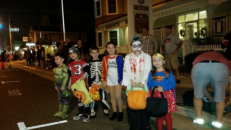 Children dressed in spooky costumes waited to scoop up the free candy that was thrown by parade marchers.