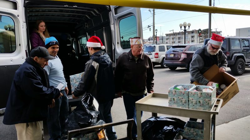 The mayor, left, is helped by local volunteers while loading toys and food into a van.