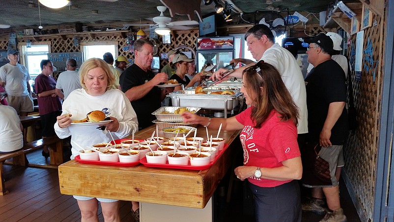 Beach cleanup volunteers savor the complimentary buffet sponsored by Mike's Seafood.